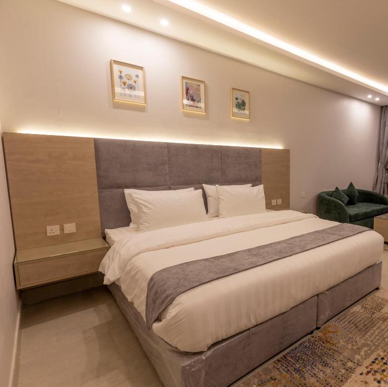- une chambre avec un grand lit et une grande tête de lit dans l'établissement شقق أحلى الأيام للوحدات السكنية المفروشة, à Muhayil