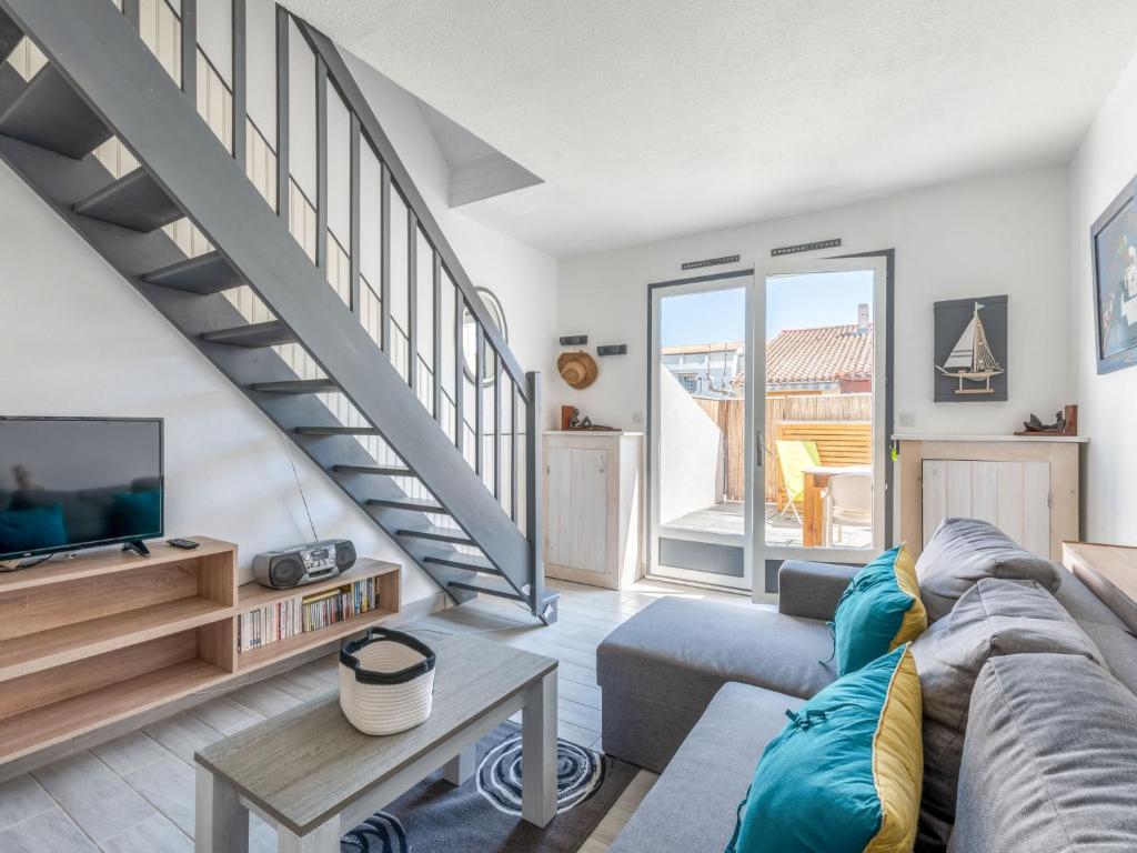 un salon avec un canapé et un escalier dans l'établissement Holiday Home Les Maisons de la Plage-12 by Interhome, au Grau-du-Roi