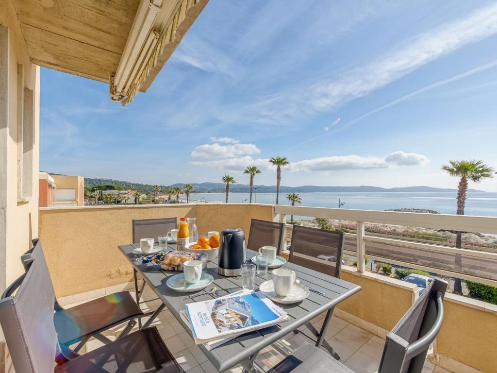 une table et des chaises sur un balcon avec vue sur l'océan dans l'établissement Apartment Le Palazzo del Mar-11 by Interhome, à Cavalaire-sur-Mer