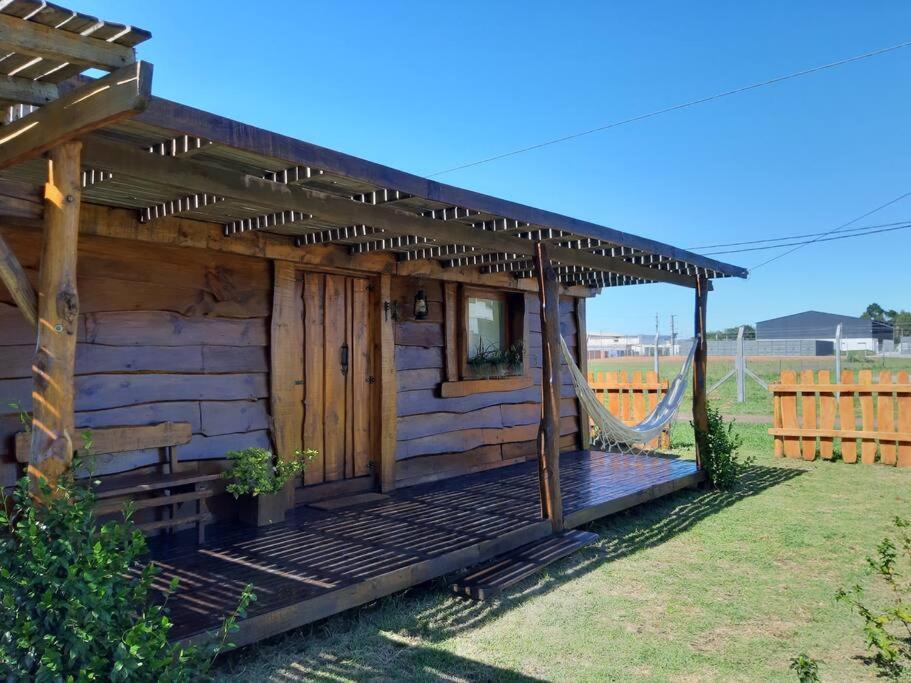 Cabaña de madera con hamaca en un patio en La Cabaña de Sofi en Tandil