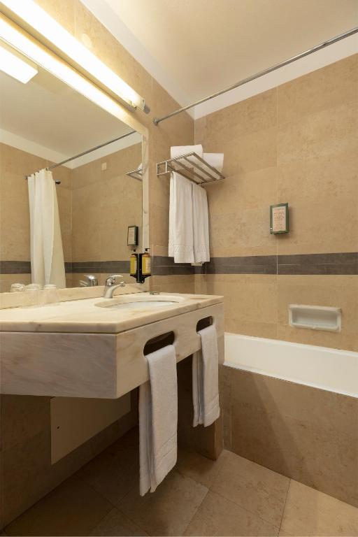 a bathroom with a sink and a large mirror at Interpass Vau Hotel Apartamentos in Portimão