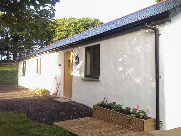 a small white house with a window and a porch at Vine Cottage in Saint Ewe