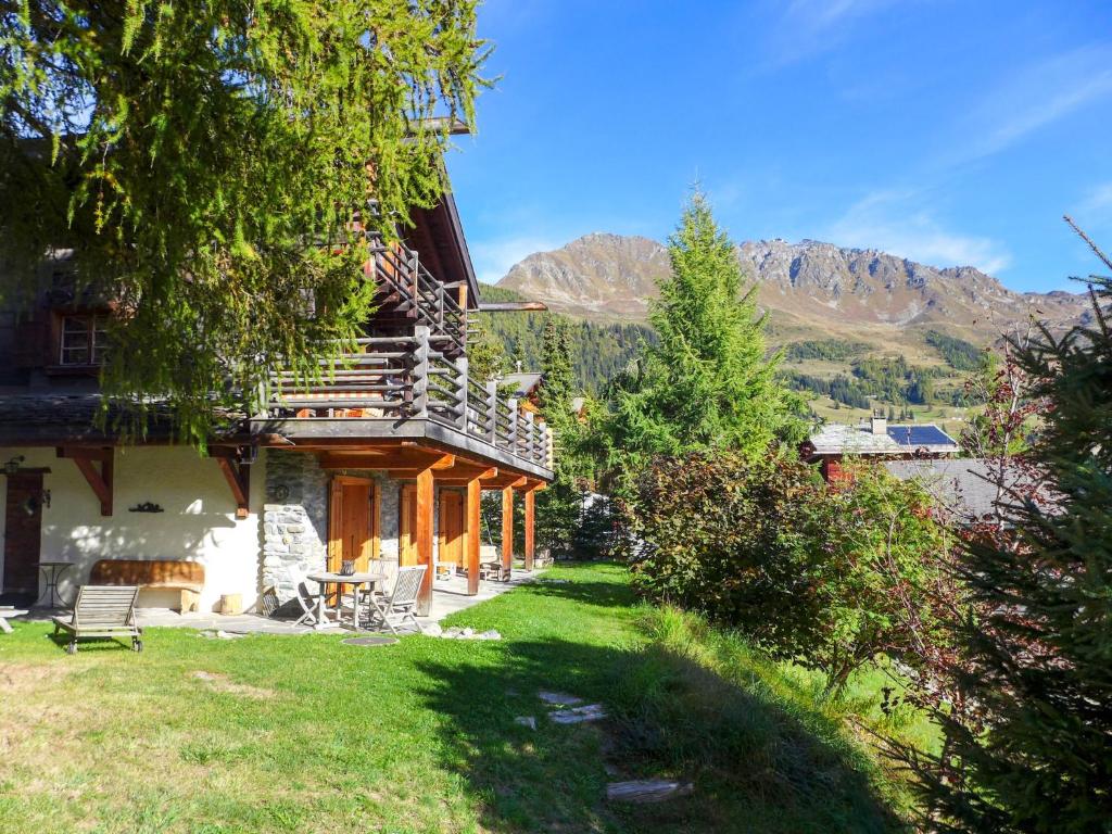 a house with mountains in the background with a yard at Chalet Filaos by Interhome in Verbier