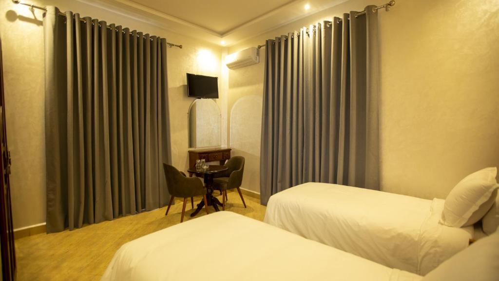 卡薩布蘭卡的住宿－Hotel de paris，酒店客房设有两张床和一张桌子。