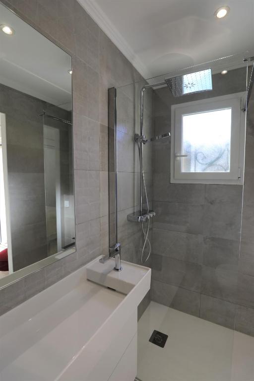 a bathroom with a sink and a shower with a mirror at Hôtel confidentiel Le Grecale in Pianottoli-Caldarello