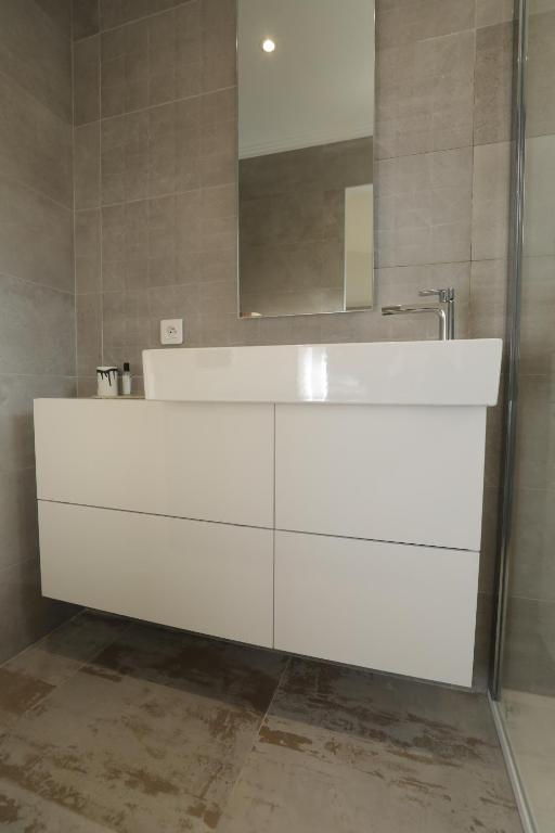 a white tub in a bathroom with a mirror at Hôtel confidentiel Le Grecale in Pianottoli-Caldarello