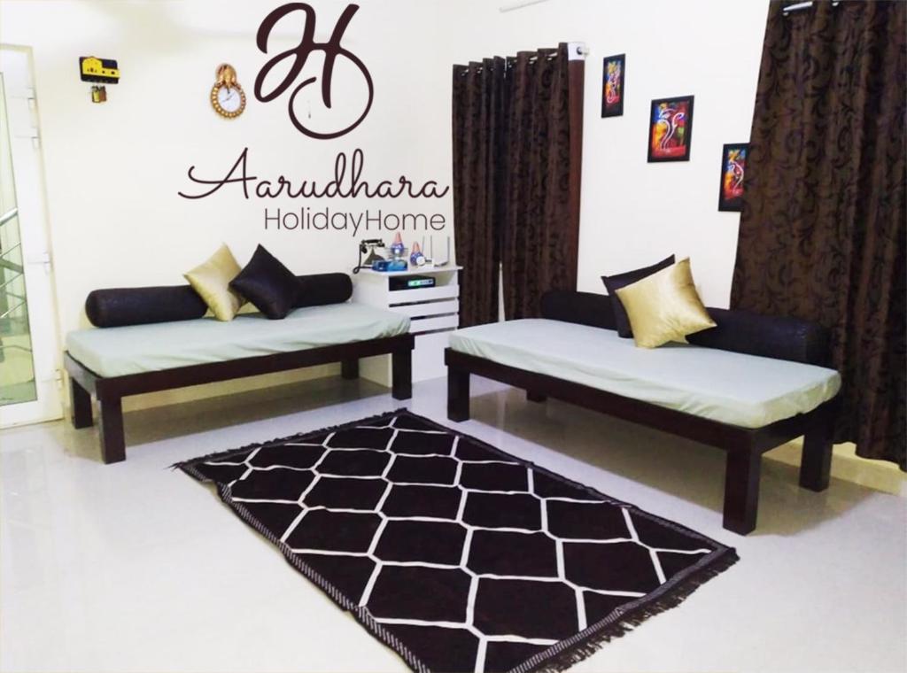 a living room with two couches and a rug at Aarudhara Holiday Home (A Home away from Home) in Puducherry