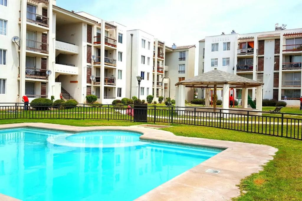 - une piscine avec un kiosque et des immeubles d'appartements dans l'établissement Monaco 422, à La Serena