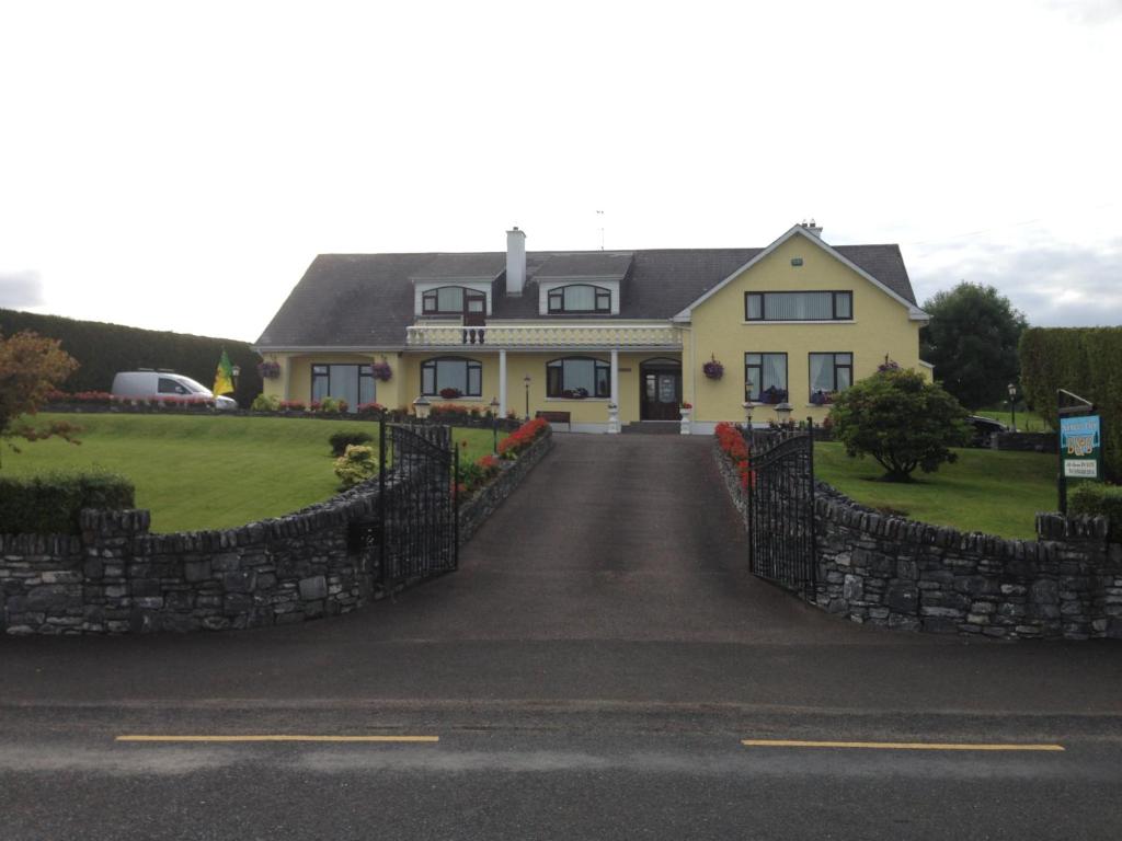 a large yellow house with a stone fence at Seawater View Accomadation - Accommodation only in Red Castle