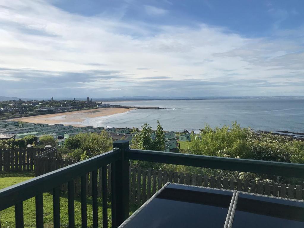 a balcony with a view of a beach and the ocean at Seascape in St Andrews