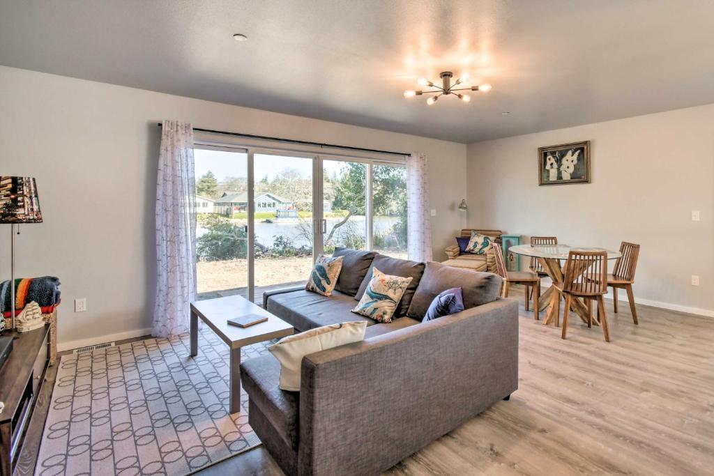 a living room with a couch and a table at Canal Cottage Retreat with Dock and Waterfront Views in Ocean Shores