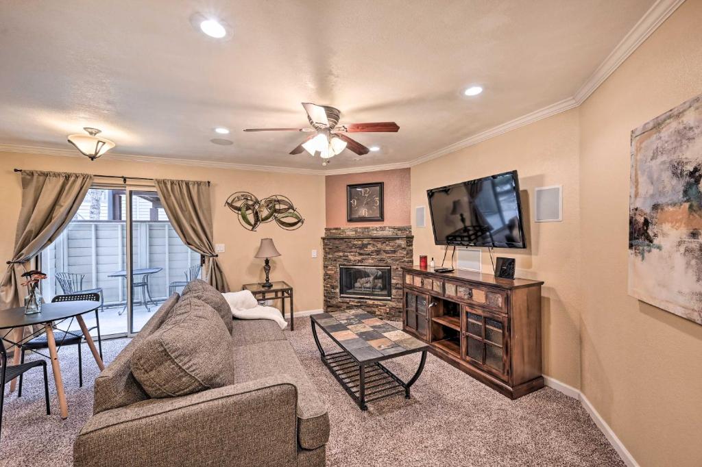a living room with a couch and a tv at Charming Greenwood Village Condo with Patio! in Greenwood Village