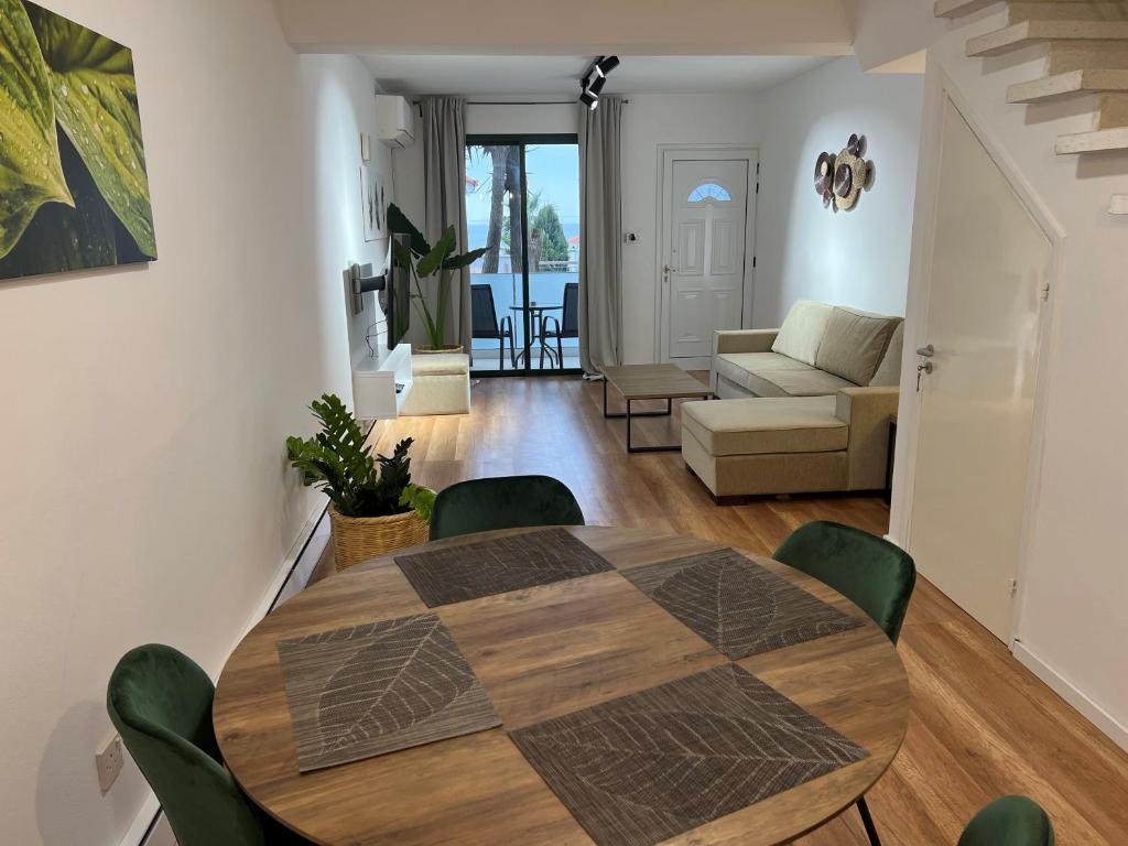 a dining room table and chairs in a living room at Julipapas Gardens in Paphos