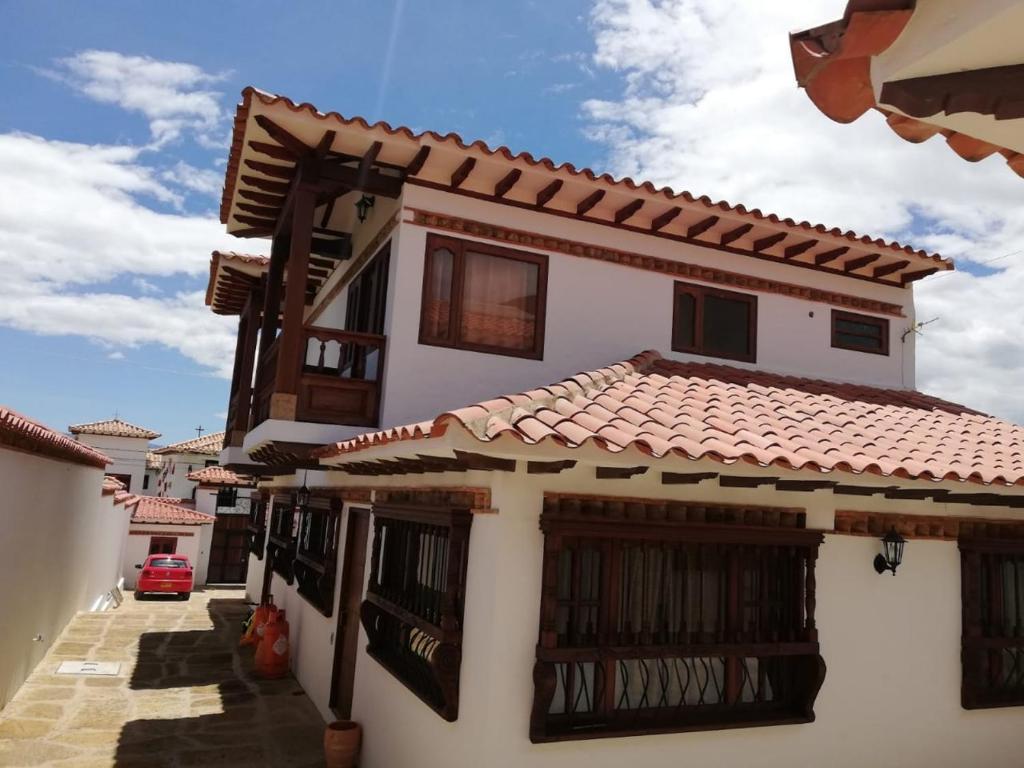 Casa blanca con techo de baldosas rojas en Cabañas la villa, en Villa de Leyva