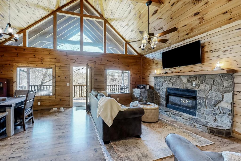 a living room with a stone fireplace and a tv at Parton Ways in Pigeon Forge