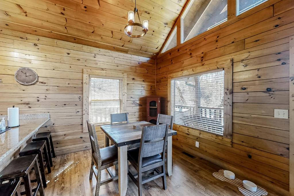 a dining room with a table and chairs in a cabin at Parton Ways in Pigeon Forge