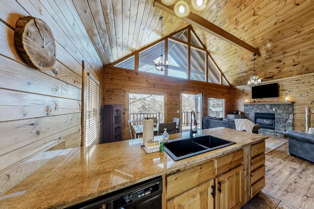 a kitchen with a sink and a living room at Parton Ways in Pigeon Forge