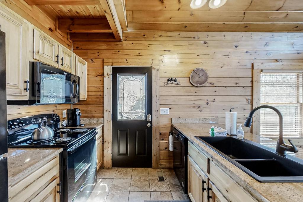 a kitchen with a sink and a black door at Parton Ways in Pigeon Forge