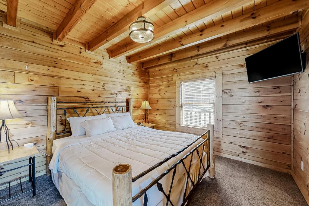 a bedroom with a bed in a log cabin at Parton Ways in Pigeon Forge