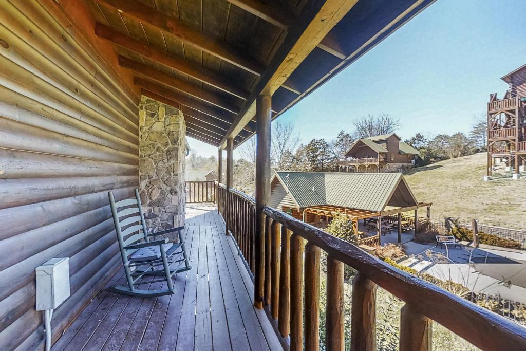 a porch of a cabin with two chairs and a table at Parton Ways in Pigeon Forge