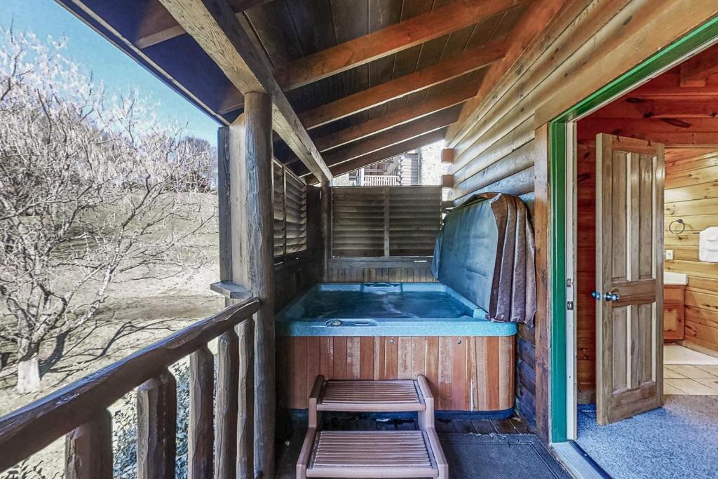 a jacuzzi tub on the porch of a cabin at Parton Ways in Pigeon Forge