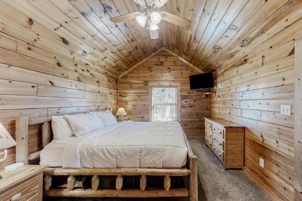 a bedroom with a bed in a wooden cabin at Parton Ways in Pigeon Forge