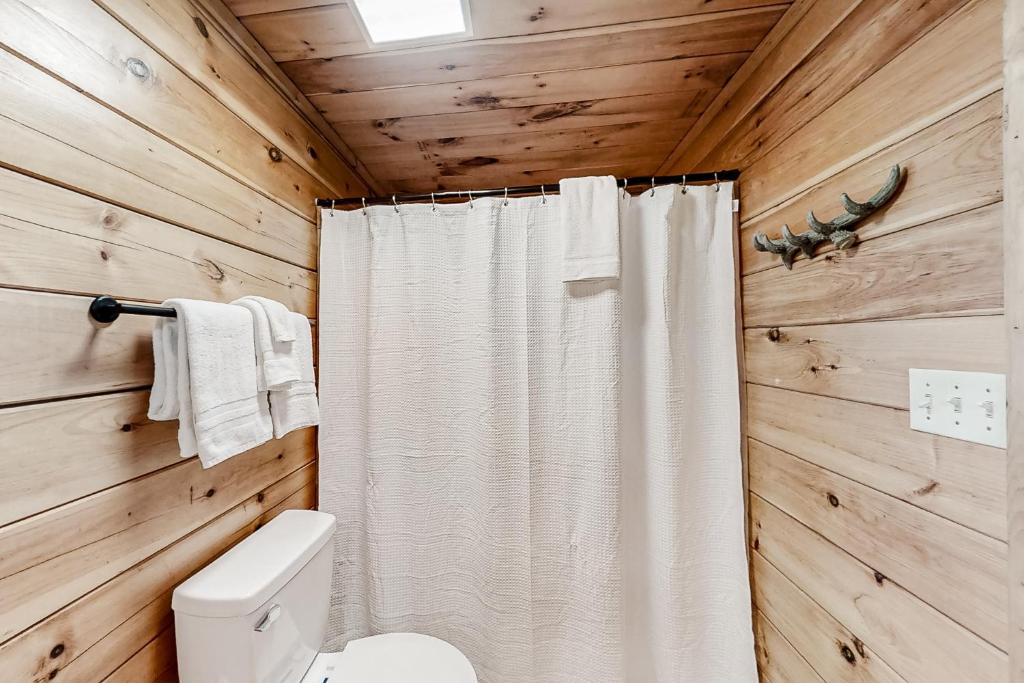 a bathroom with a white shower curtain and a toilet at Parton Ways in Pigeon Forge