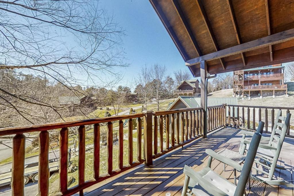a porch with two chairs on a wooden deck at Parton Ways in Pigeon Forge