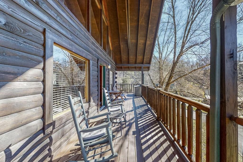 a deck with chairs on the side of a cabin at Parton Ways in Pigeon Forge