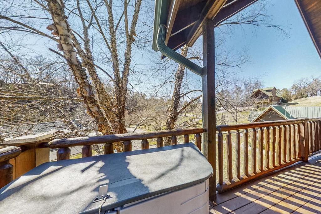 a snow covered deck with a hot tub on a porch at Parton Ways in Pigeon Forge
