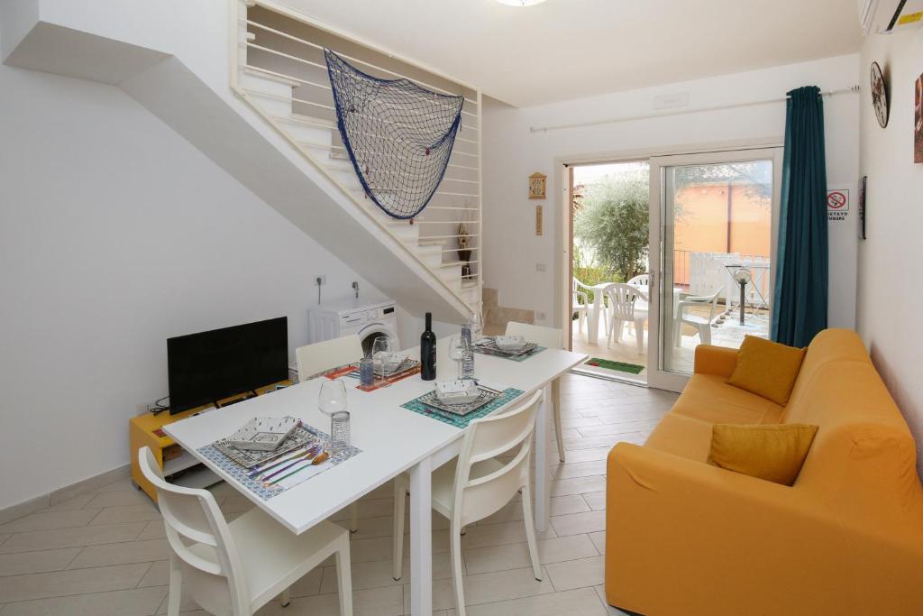 a kitchen and living room with a table and chairs at KATE HOME in Viddalba