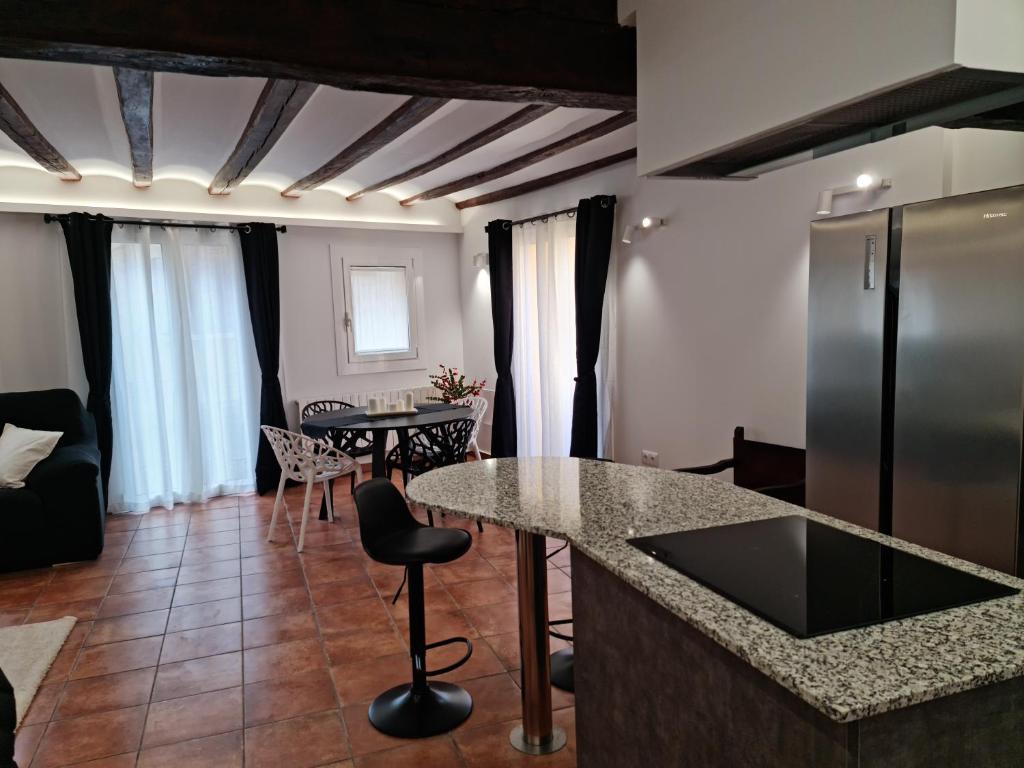 eine Küche und ein Wohnzimmer mit einer Theke und einem Tisch in der Unterkunft Ca la Núria in La Seu d'Urgell