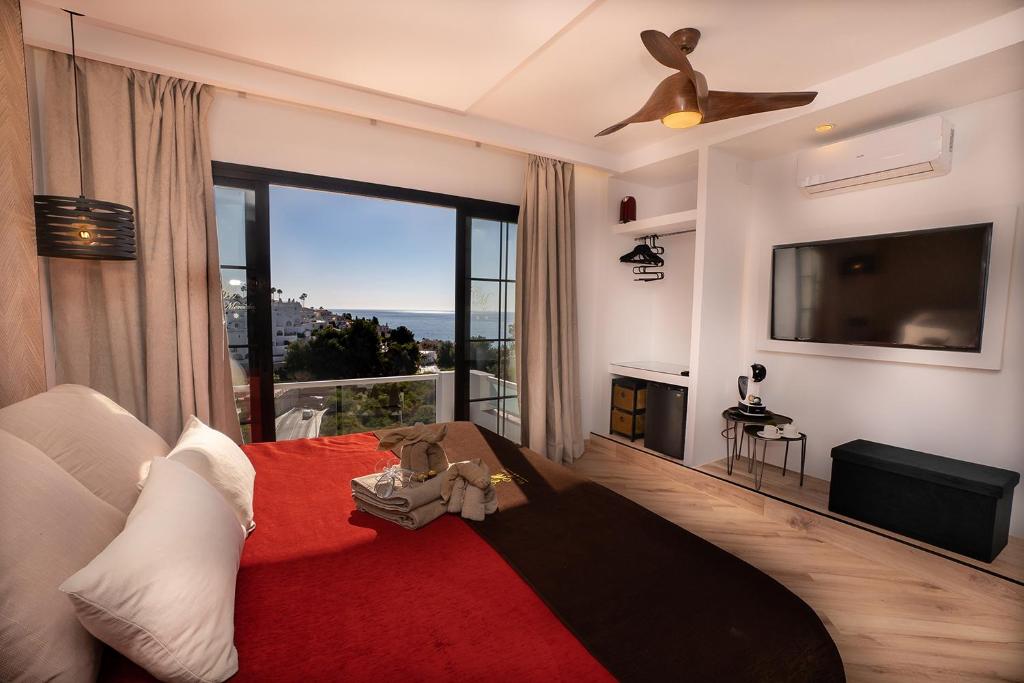 a living room with a couch and a ceiling fan at Hostal Casa Mercedes in Nerja