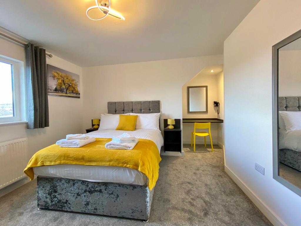 a bedroom with a bed with a yellow blanket on it at Paddington by Pureserviced in Plymouth