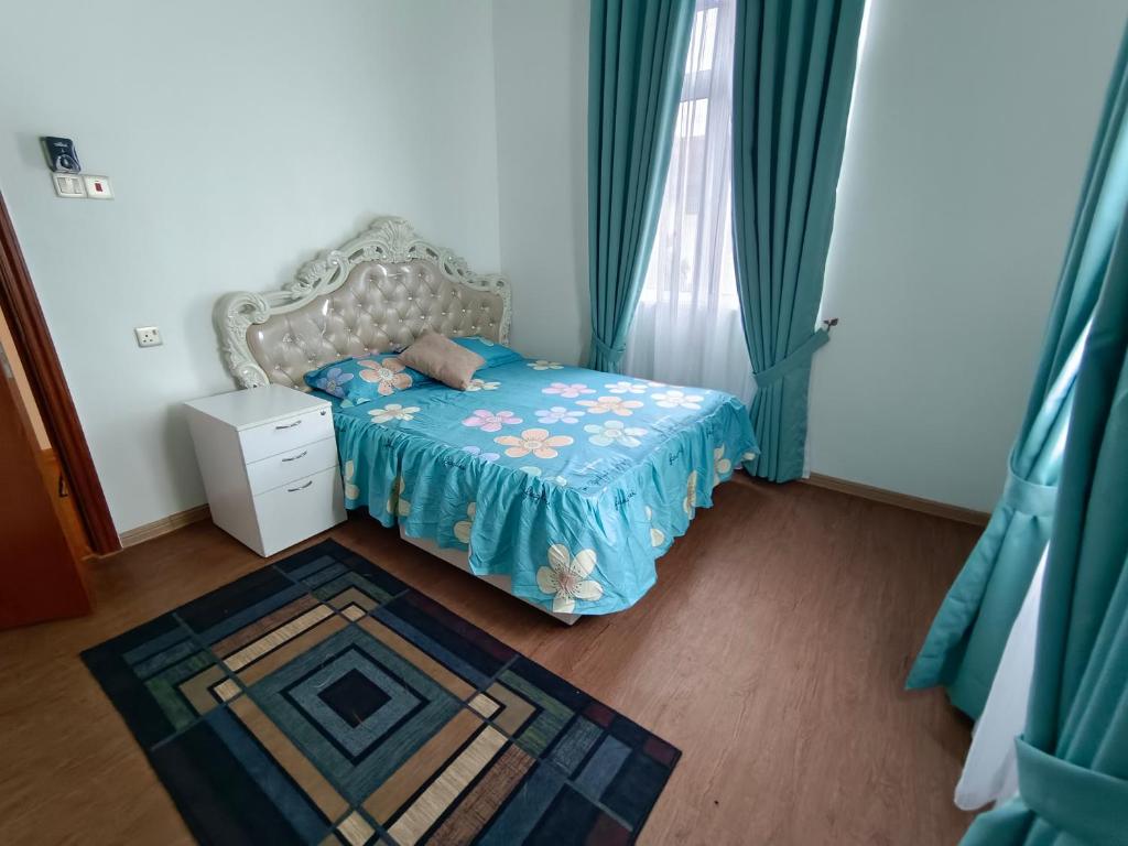 a small bedroom with a bed with a blue blanket at LUXURY Modern House Kubang Kerian UNIFI 4 Bedrooms in Kota Bharu