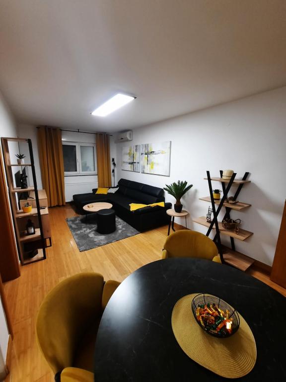 a living room with a black table and chairs at Apartman Ares in Osijek