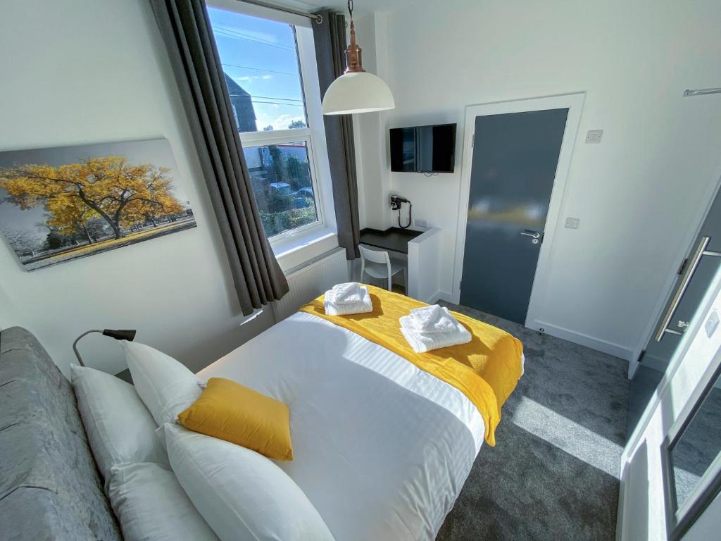 a bedroom with a bed with a yellow blanket at Piccadilly by Pureserviced in Plymouth