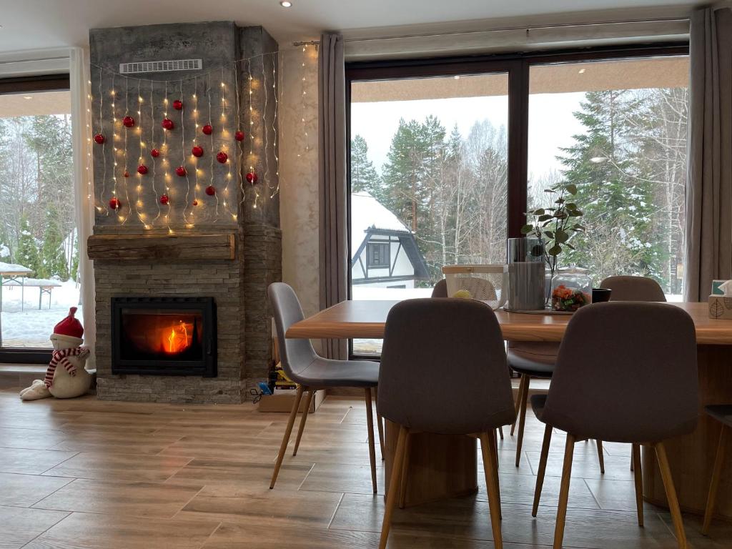 ein Esszimmer mit Tisch und Kamin in der Unterkunft Apartman Una in Divčibare