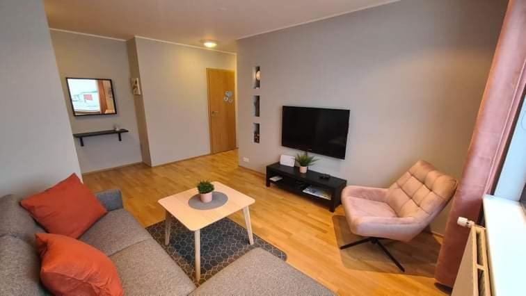 a living room with a couch and a chair and a television at Kirkjufell central apartment in Grundarfjordur