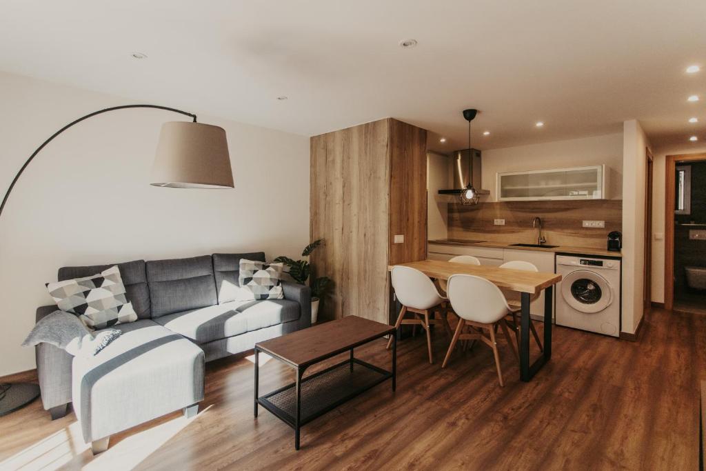 een woonkamer met een bank en een tafel bij Apartaments 7Gorgs in Campdevánol