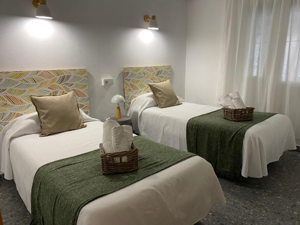 a hotel room with two beds with green sheets at Hostal Paco Marbella in Marbella