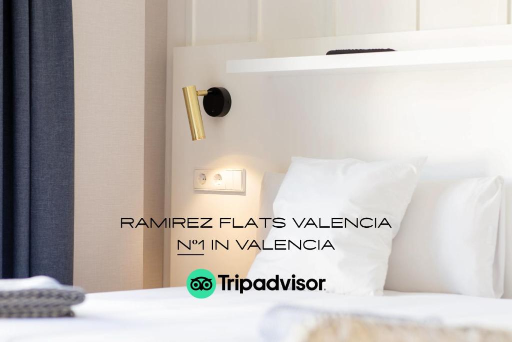 un letto con cuscini bianchi di Ramirez Flats Valencia a Valencia