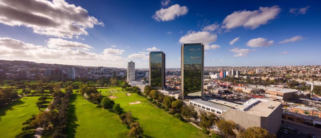 two tall buildings in a city with a park at Grand Hotel Tijuana in Tijuana