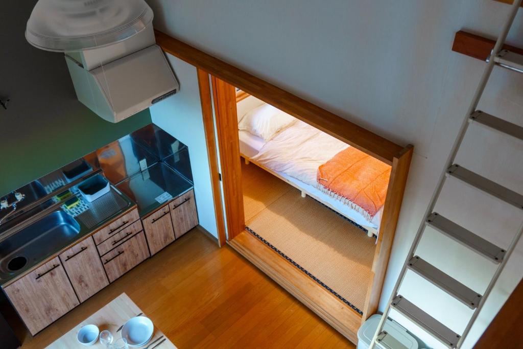 a small room with a bed and a small kitchen at La Colina Retreat - Vacation STAY 07222v in Madarao Kogen