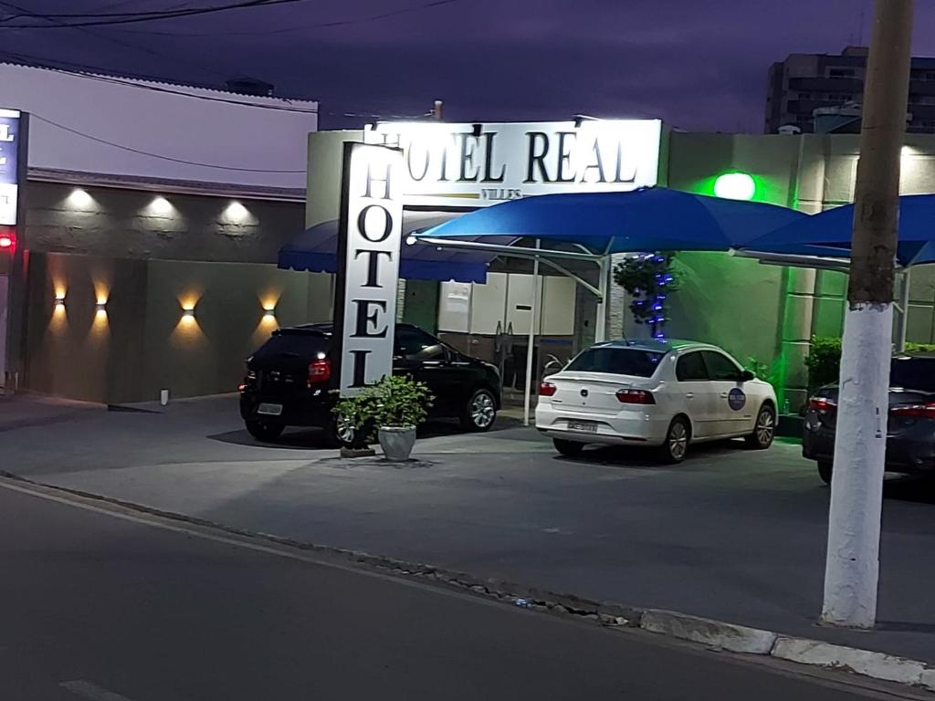 a car dealership with a sign for all real gas station at Hotel Real Villes in Várzea Grande