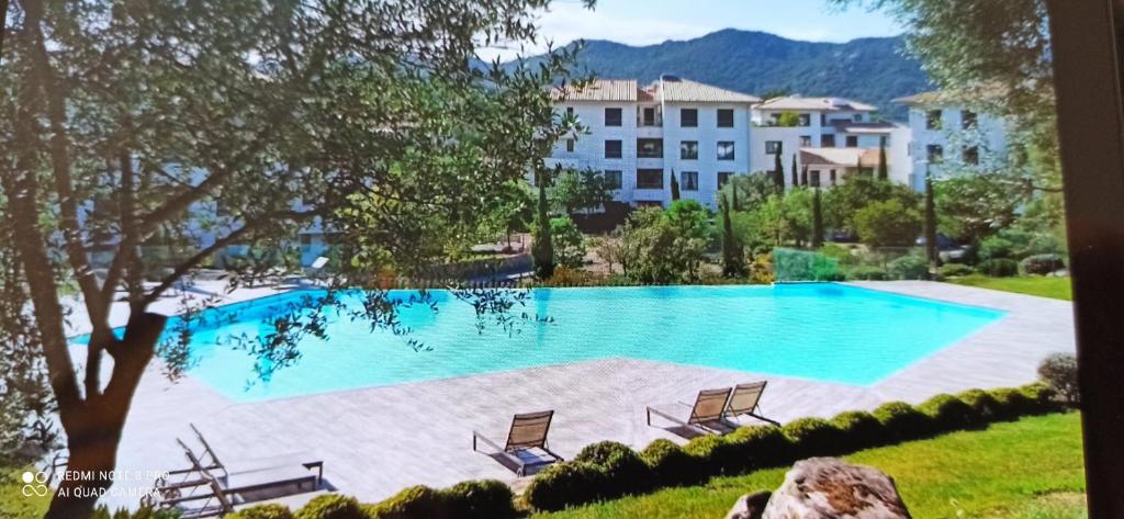 une grande piscine avec des chaises et un bâtiment dans l'établissement ARCA C14, à Porto-Vecchio