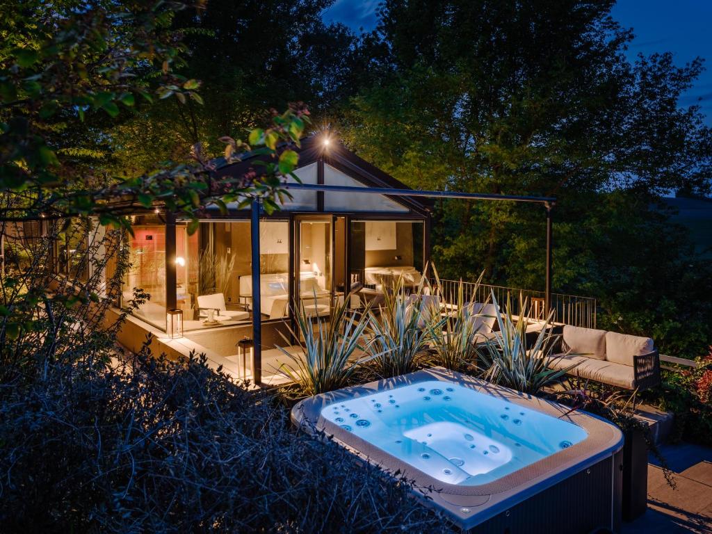 a jacuzzi tub in the yard of a house at Glass House & SPA - DCA Certified - in Terruggia