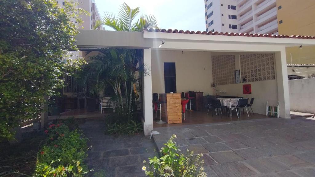 a house with a patio with a table and chairs at Casa do Uai in João Pessoa