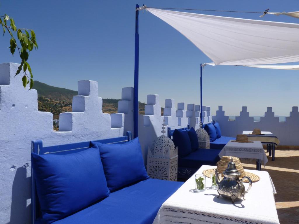 a patio with blue and white furniture and a white tent at Dar Zambra in Chefchaouen
