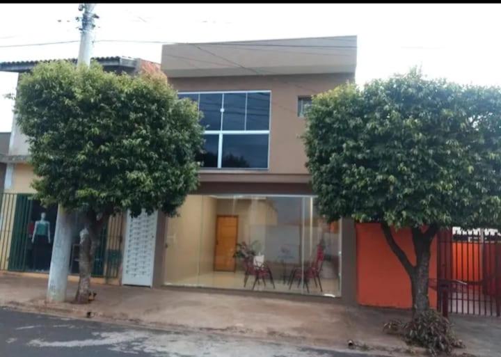 a house with two trees in front of it at Recanto Jurandir Marçal in Olímpia